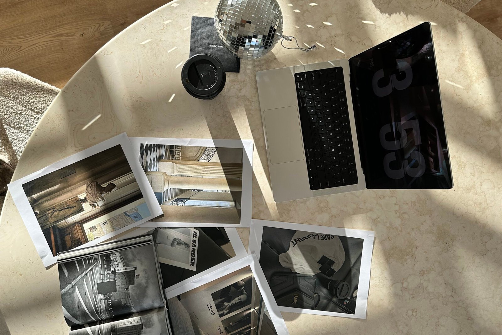 Photographs and laptop on table